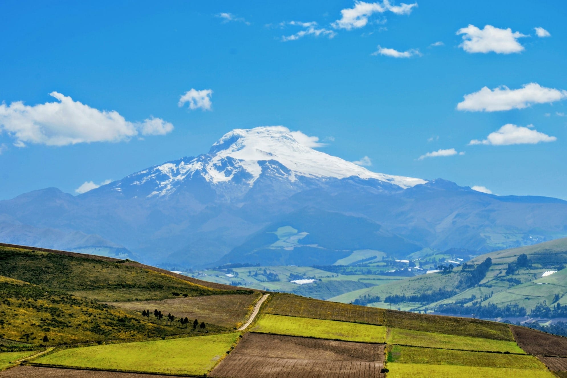 a mountain range with a snow capped peak in the distance